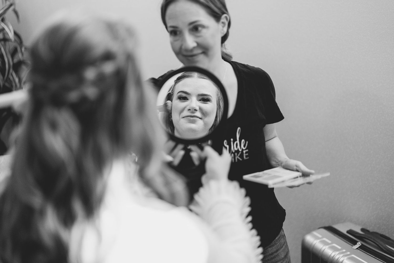 A black and white reflection of a bride getting ready in a mirror during wedding preparations. Milwaukee, Wisconsin