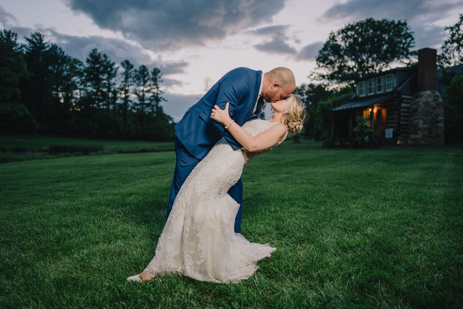 Dramatic sunset wedding photo with groom dipping bride on lawn. Washington DC.