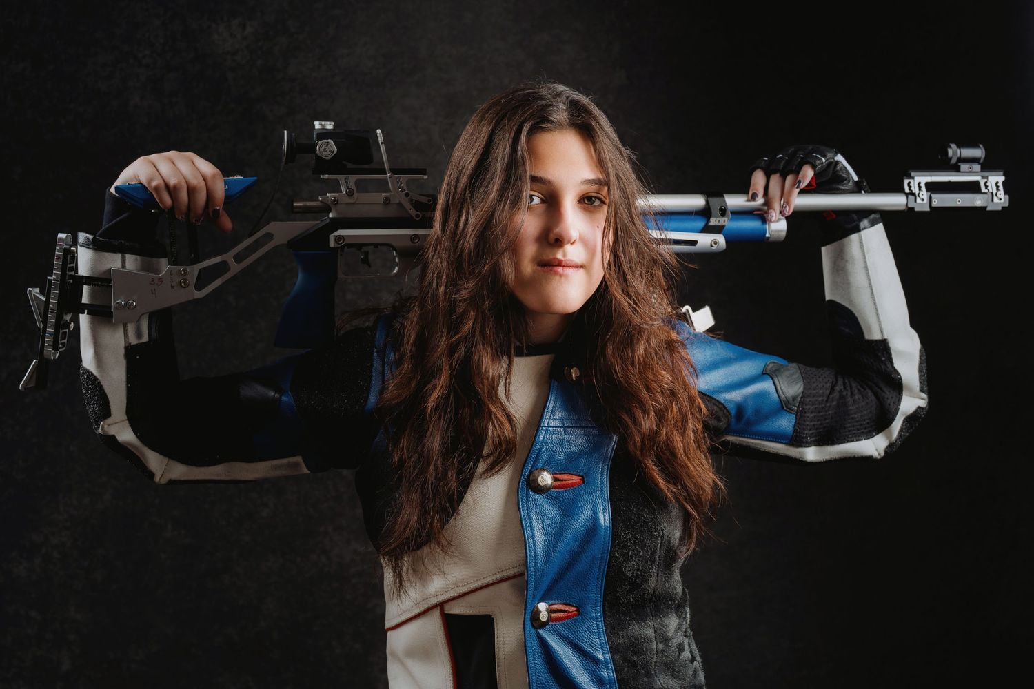 A dramatic portrait of someone holding two weapons while wearing tactical gear against a dark background. Murfreesboro, Tennessee.