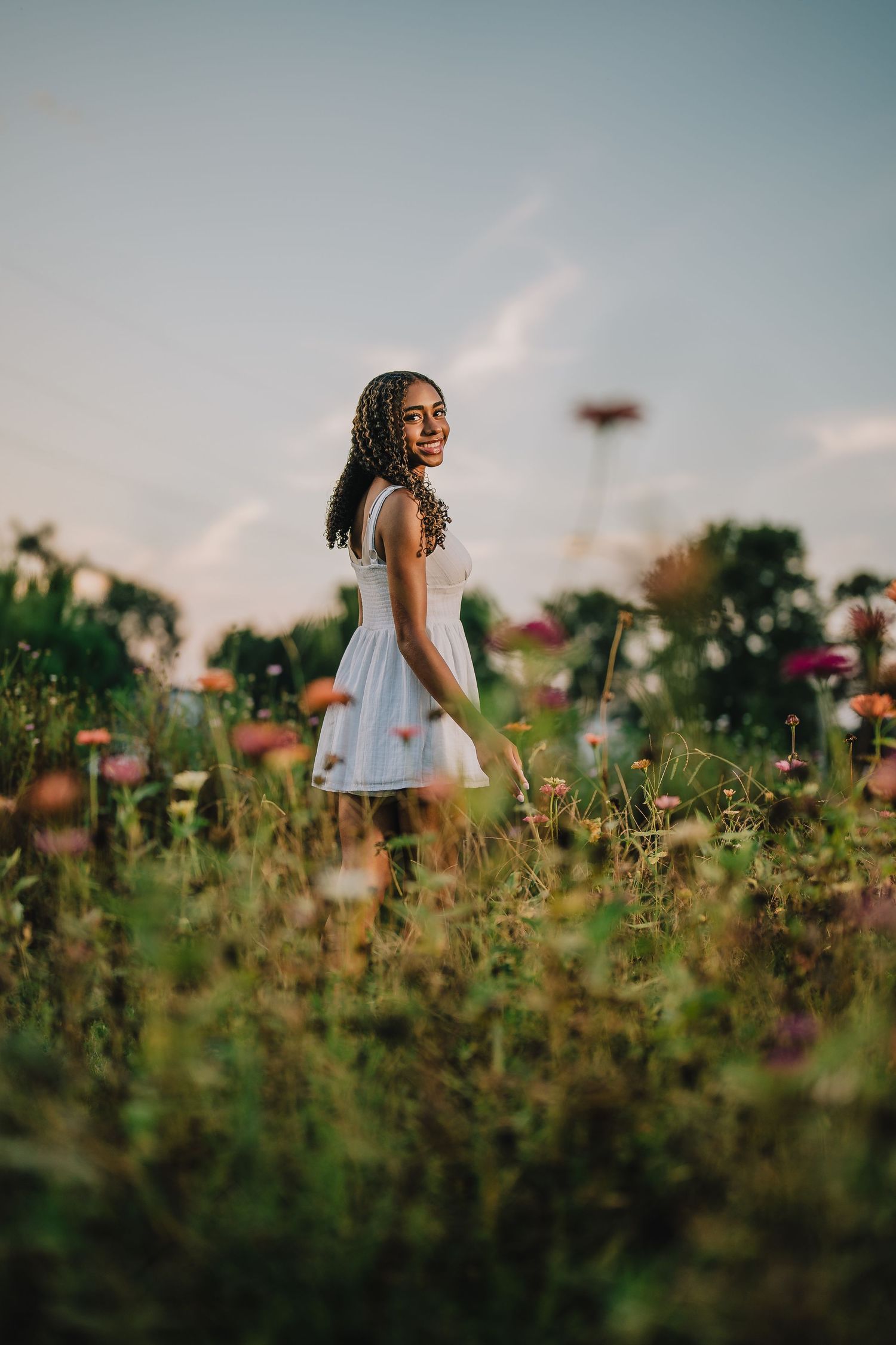 Dreamy portrait of someone in a white dress standing among wildflowers at sunset. Nashville, Tennessee.
