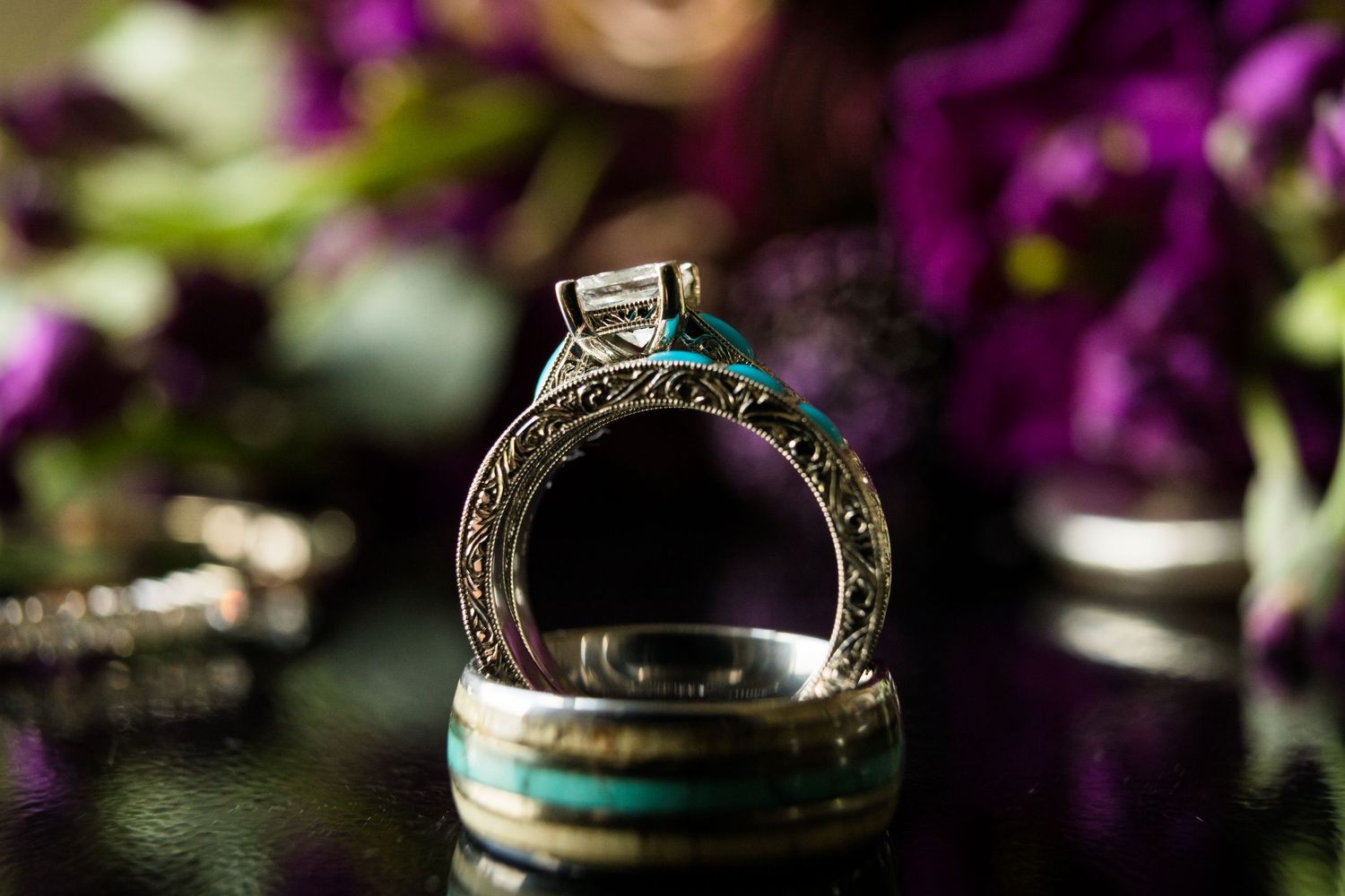 Diamond engagement ring and wedding band with purple flowers in background. The Cordelle, Nashville, Tennessee.