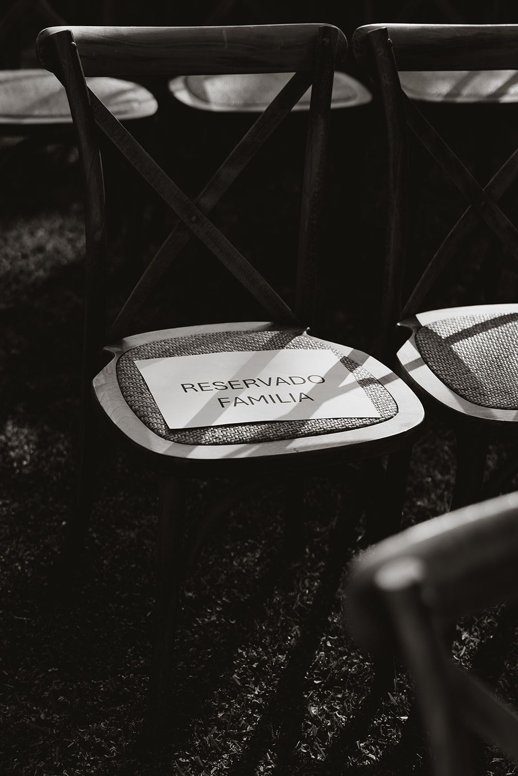 Black and white photo of a wedding chair with 'Reservado Familia' sign.