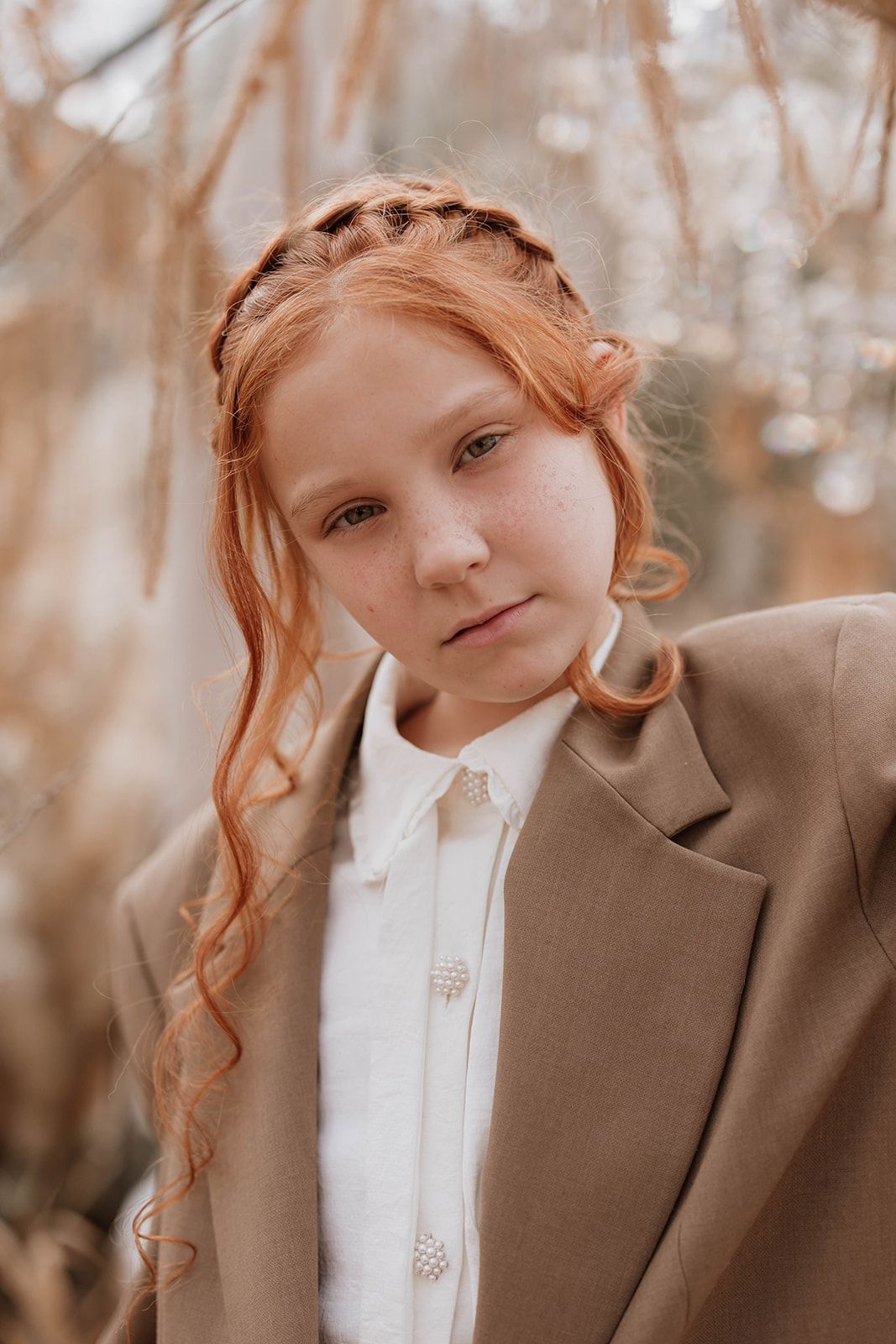 Soft autumn portrait with tan blazer and white button-up shirt in natural lighting.