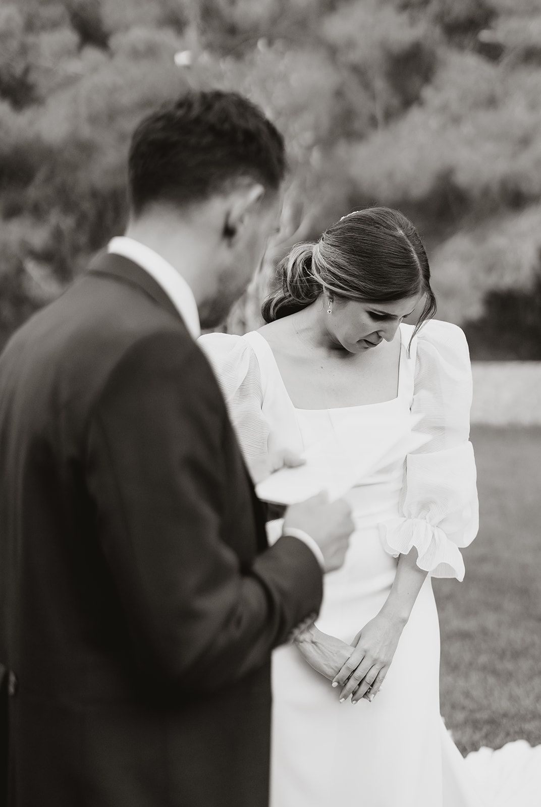 A couple sharing an intimate moment during their wedding ceremony outdoors.