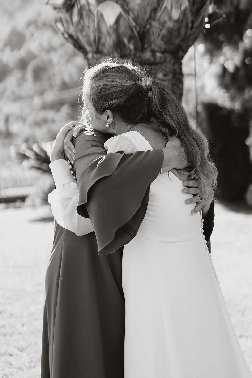 Two people share an emotional embrace in black and white photography.