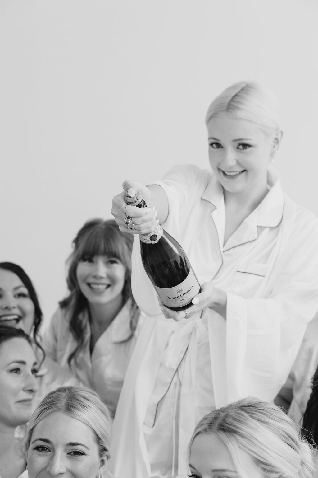 Black and white photo of celebratory moment with champagne bottle.