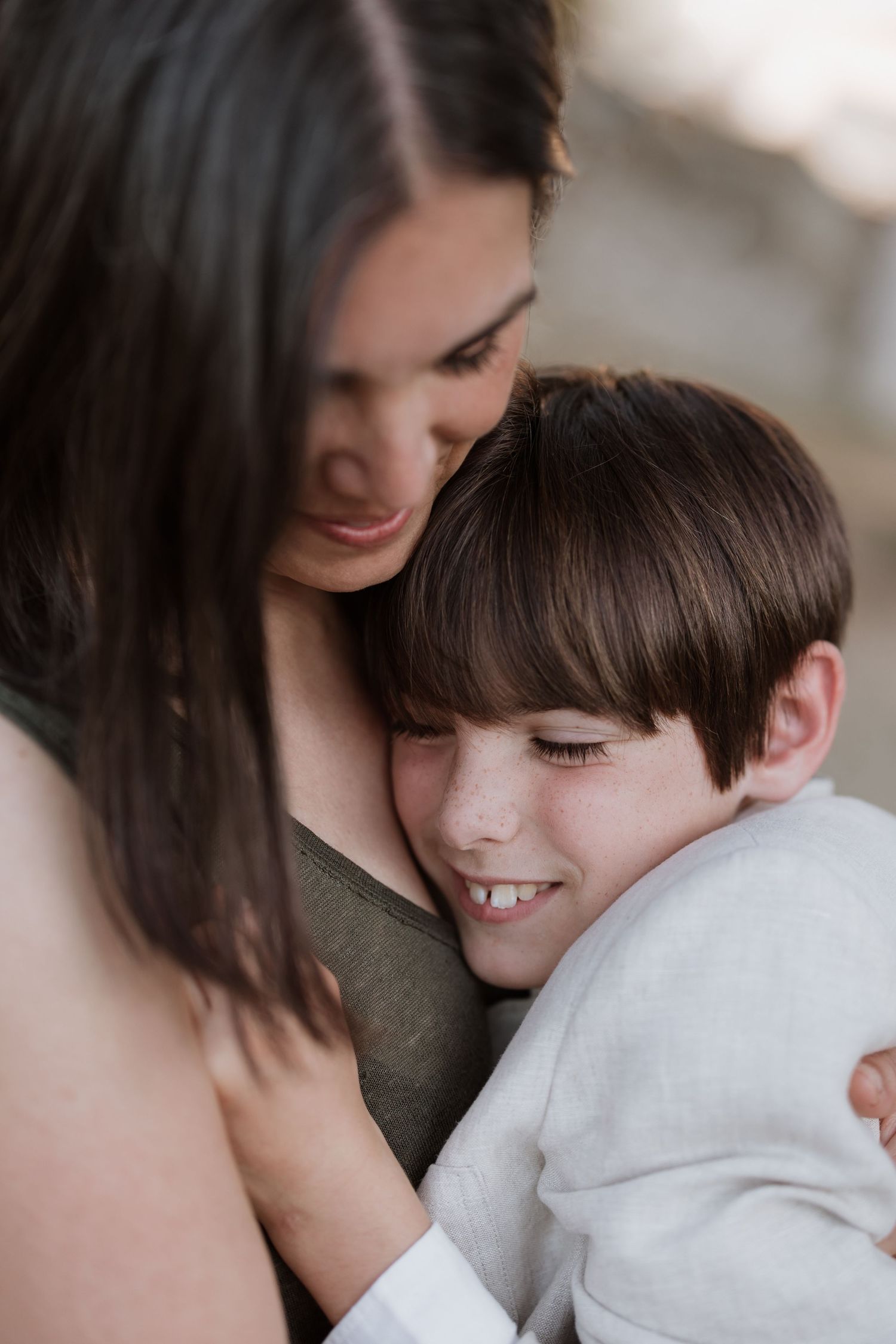 A tender moment shows a loving embrace between parent and child, both smiling warmly.