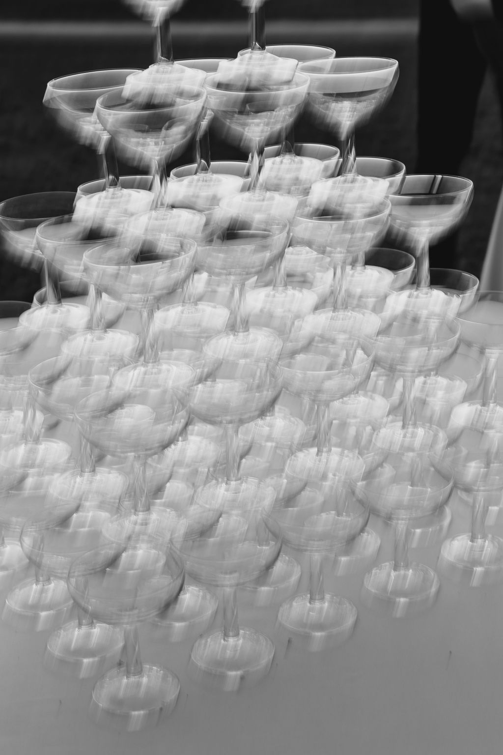 Elegant champagne tower setup with stacked coupe glasses in black and white.
