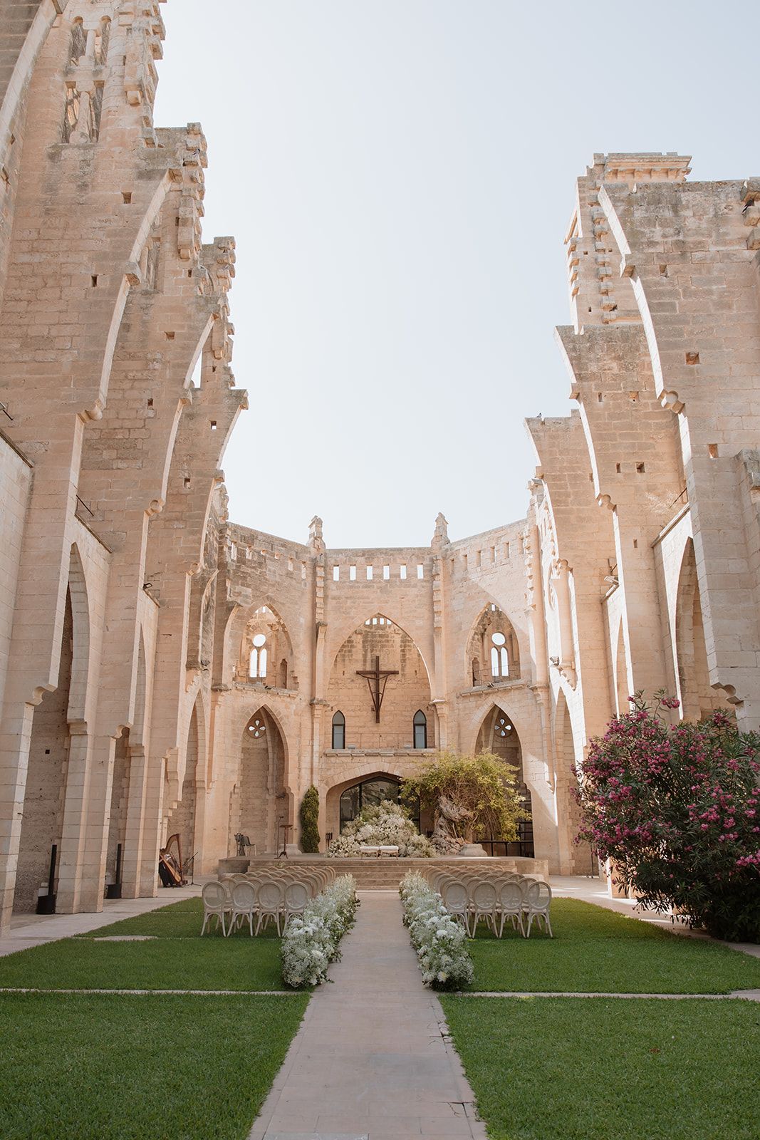Gothic stone church courtyard with symmetrical architecture and chairs set up for an outdoor wedding ceremony.