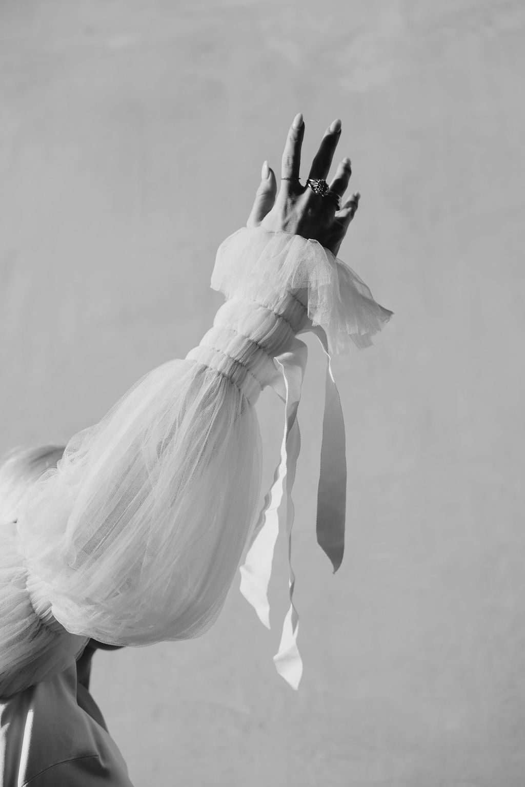 Ethereal white dress with balloon sleeves and crown captured in artistic black and white motion photography.