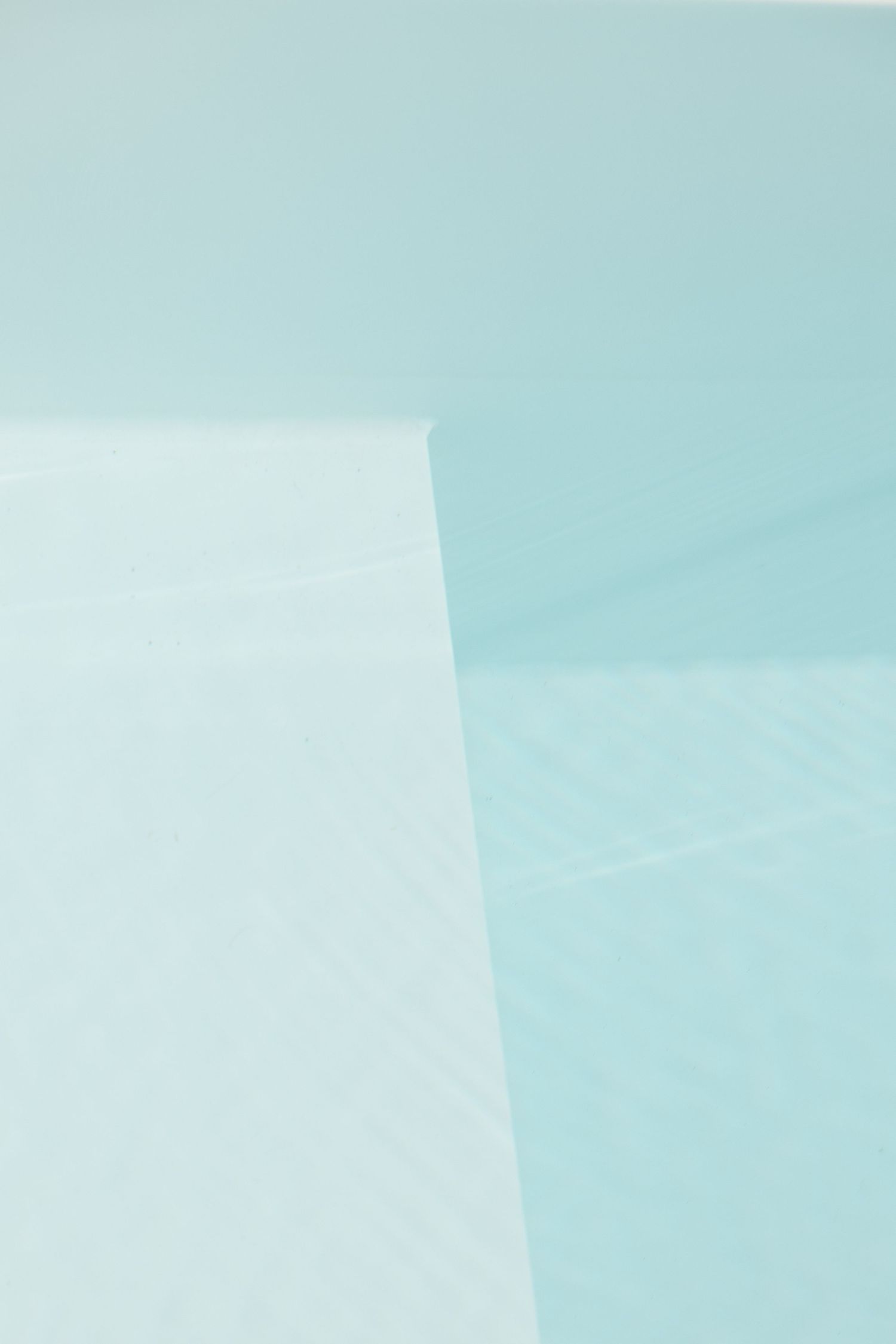 Abstract architectural detail showing intersection of white and turquoise walls.