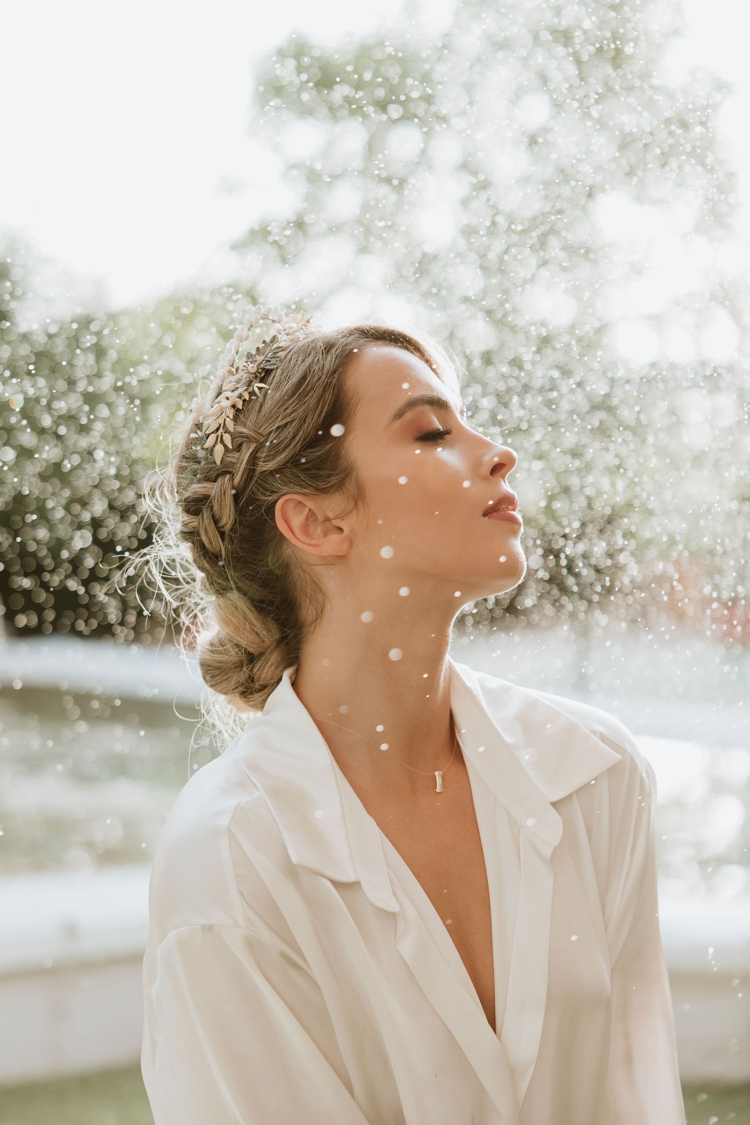 Sun-drenched portrait with water droplets creating sparkles against white collar.