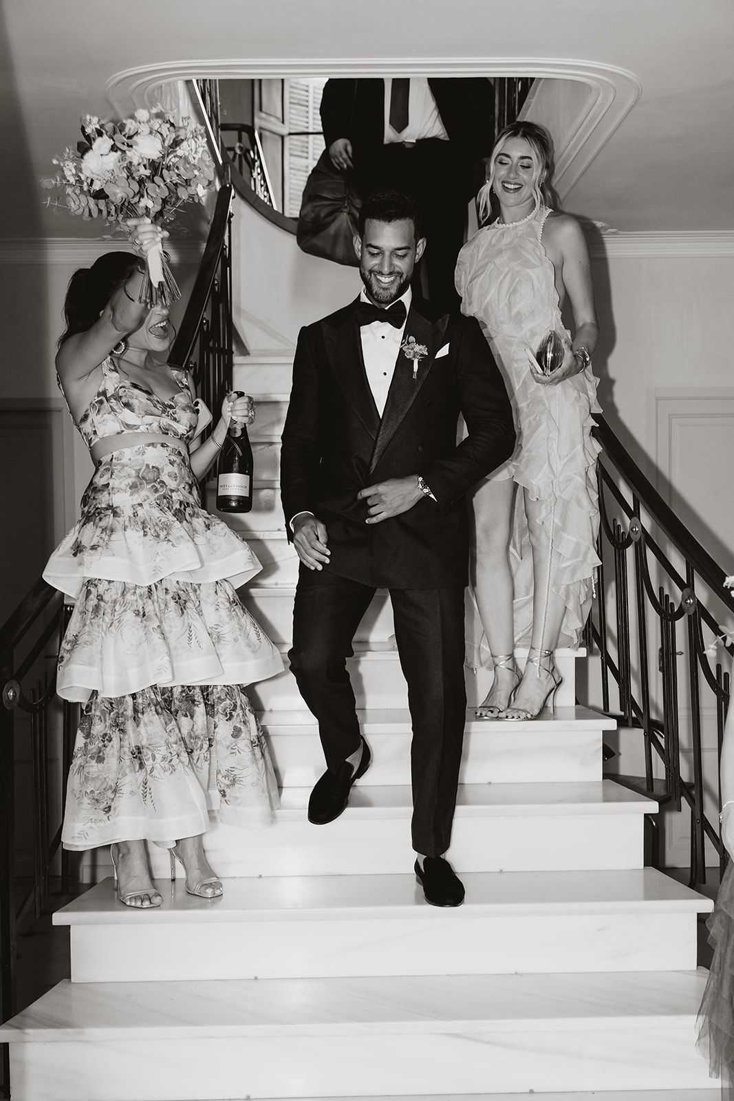Black and white photos of wedding party descending stairs in formal attire.