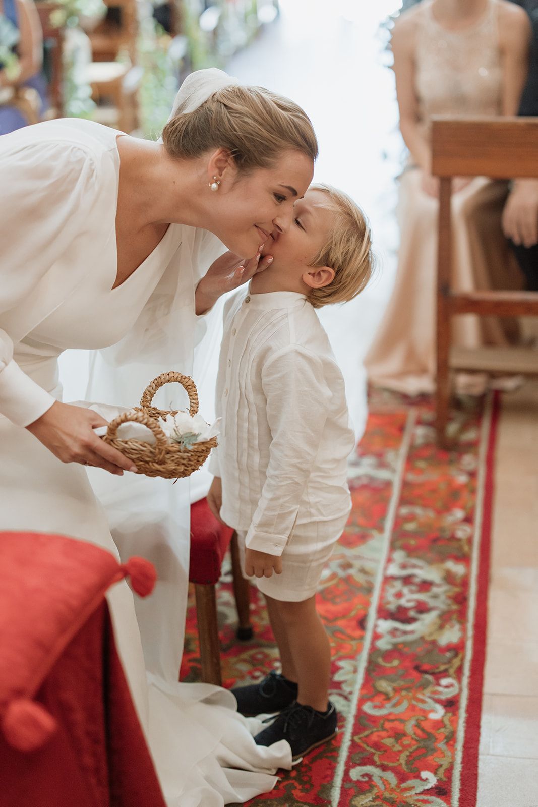 A sweet moment between bride and young ring bearer during wedding ceremony.