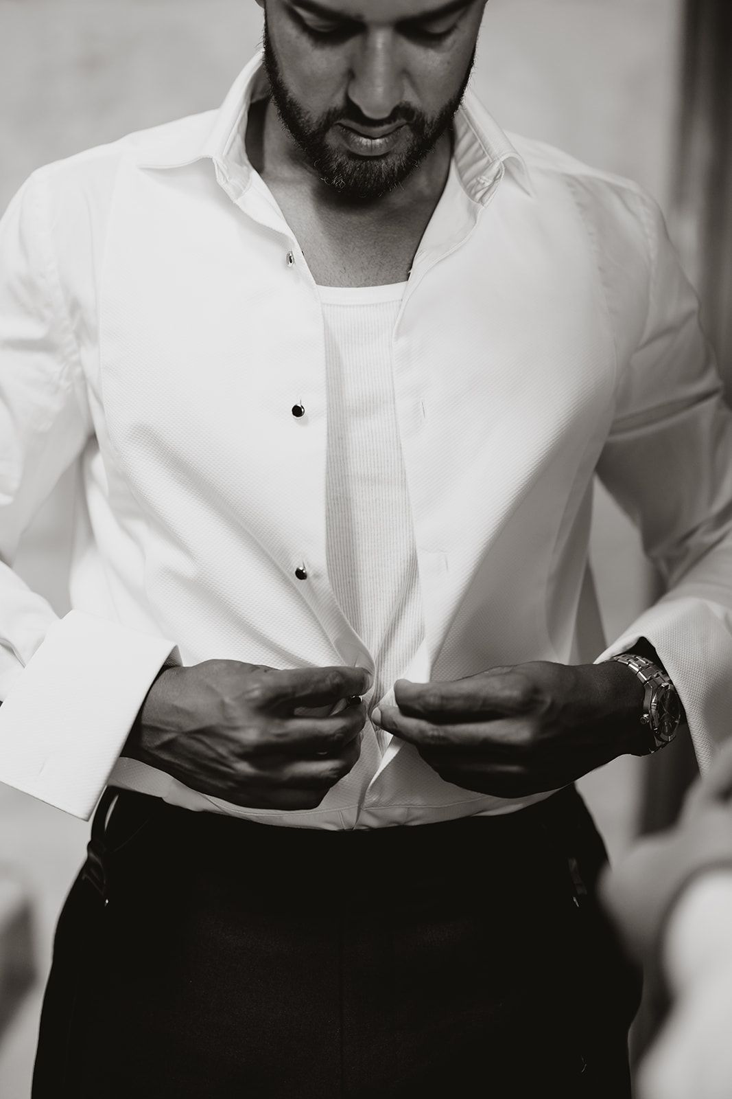 Monochrome image of formal white shirt and black cummerbund preparation.