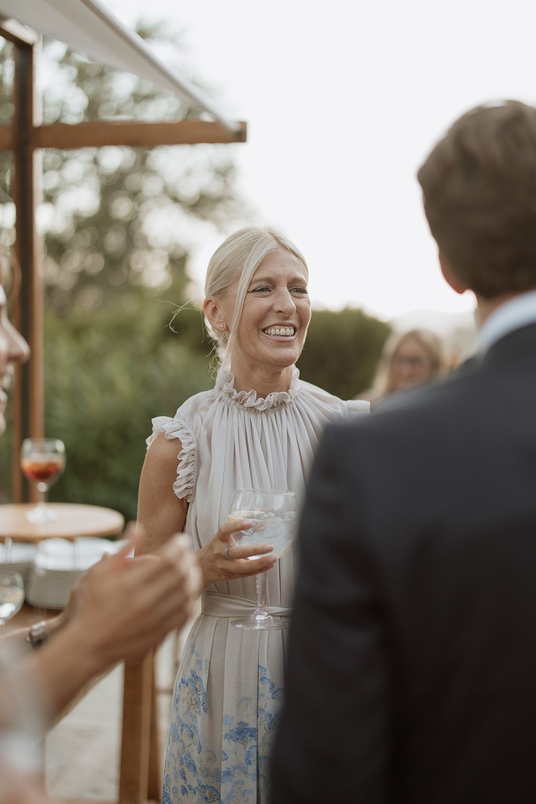 Guests enjoying drinks and conversation at outdoor wedding reception.