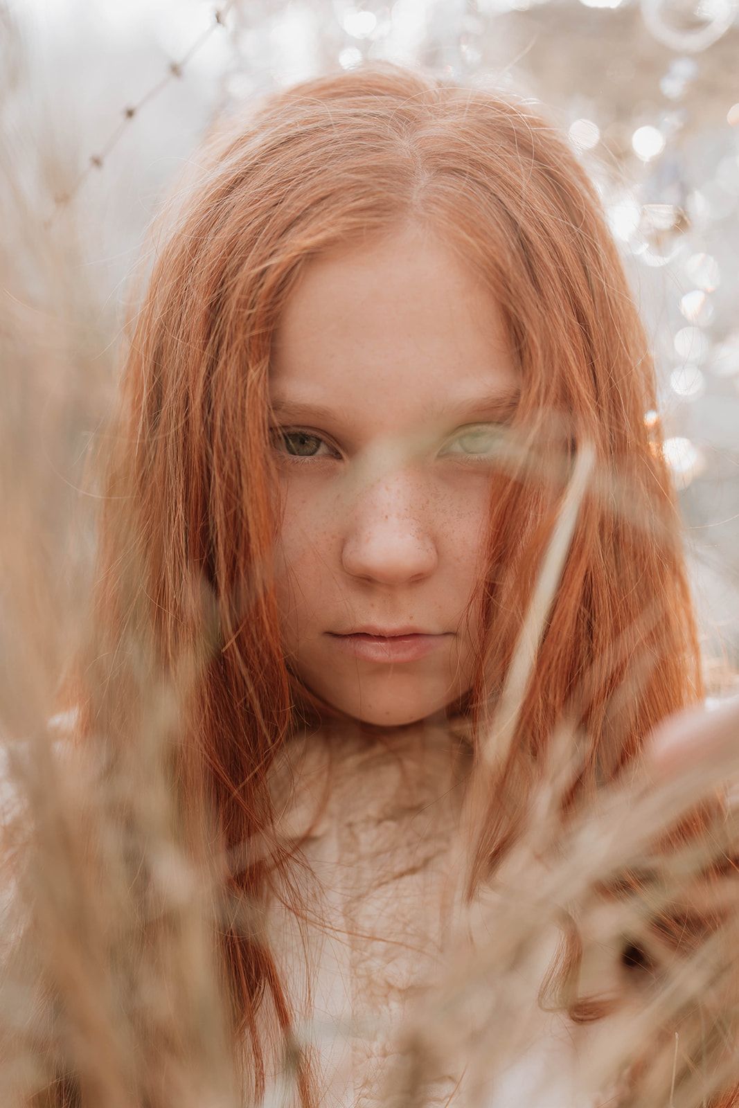 Atmospheric close-up portrait with natural elements and soft focus effects.