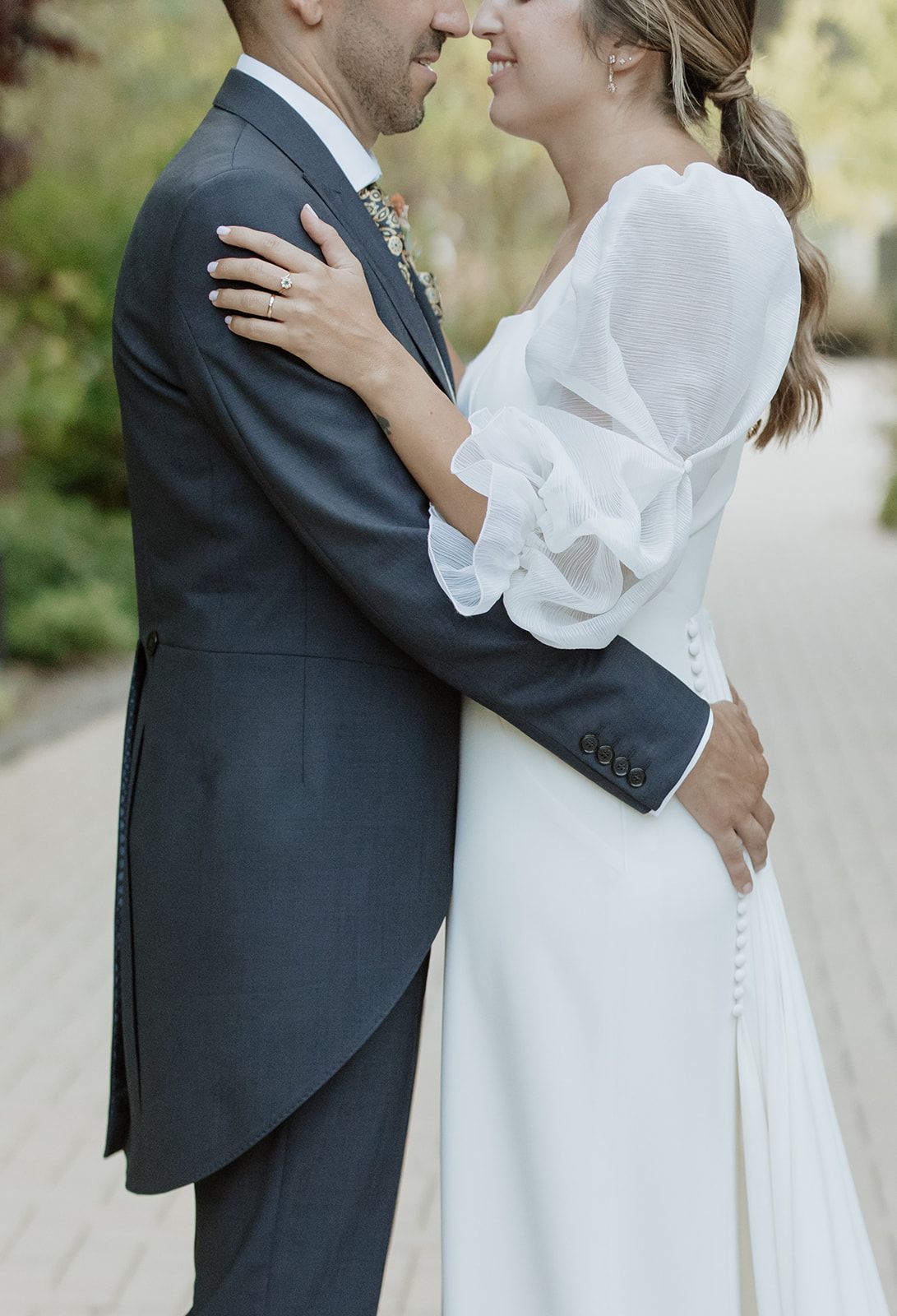 Romantic close-up of couple embracing in elegant wedding attire.
