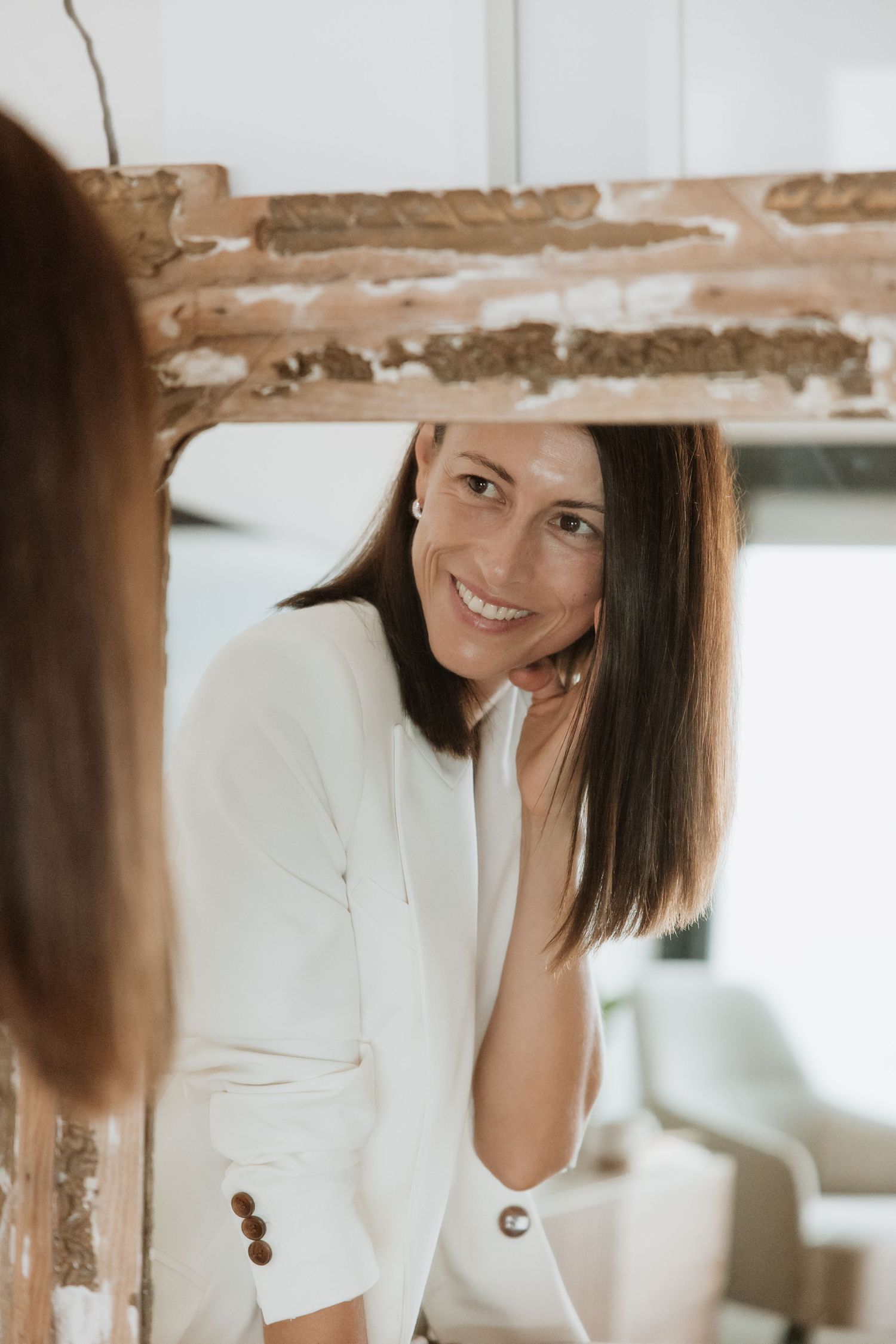 Professional portrait session in minimalist setting with rustic wall texture.
