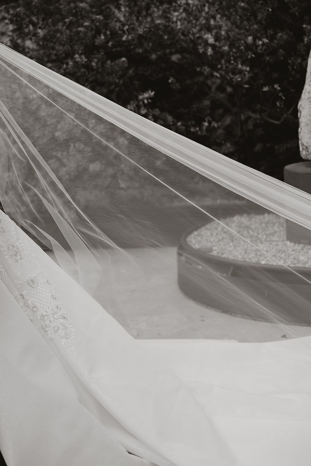 Black and white detail shot of flowing white wedding veil fabric.