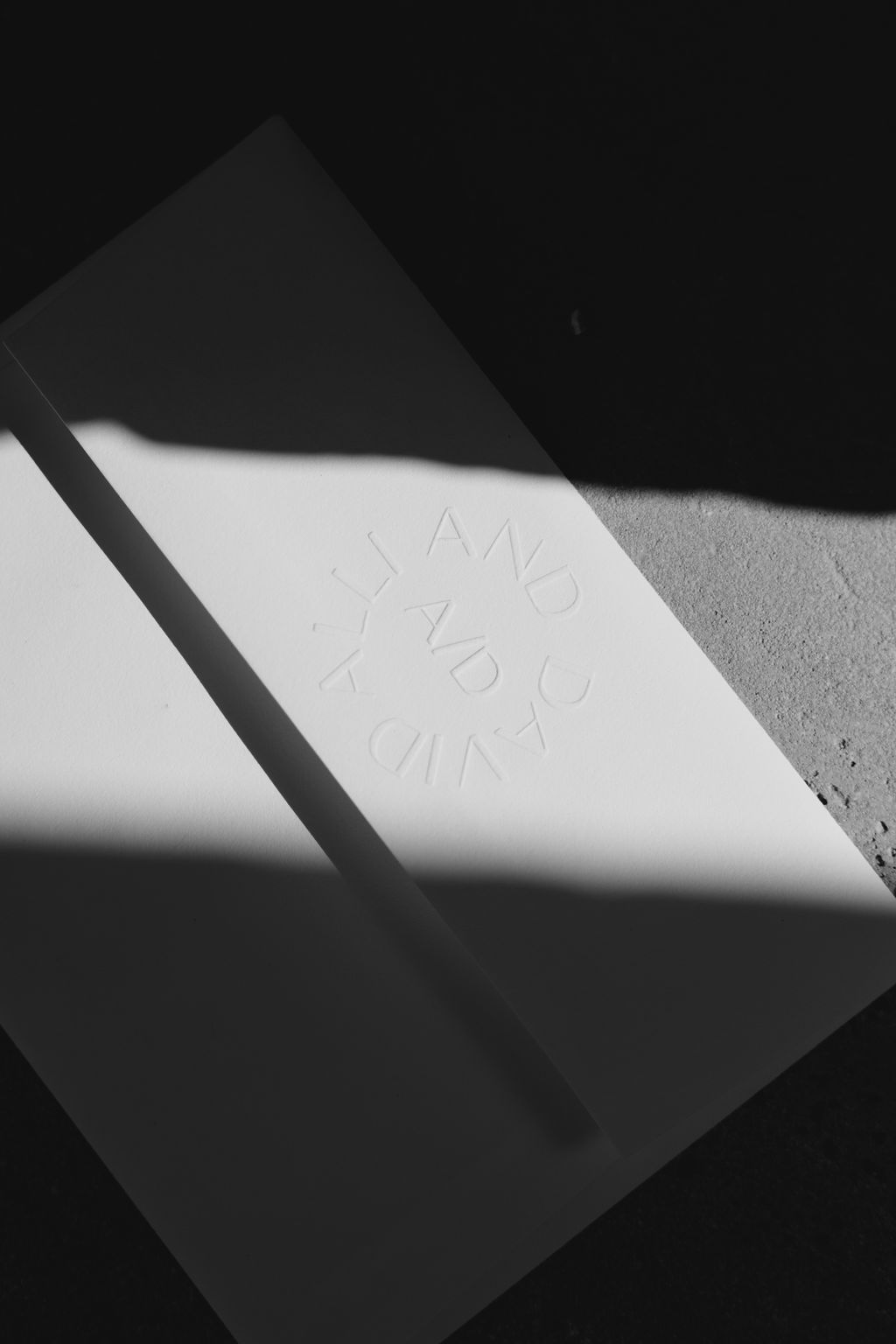 Abstract black and white image showing dramatic shadows on textured surface.