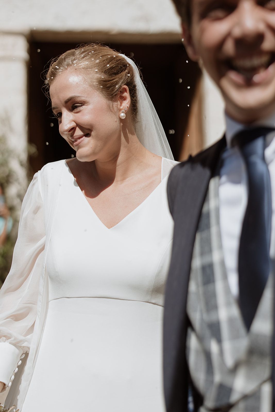 A joyful bride in a classic white dress smiles during wedding celebrations.