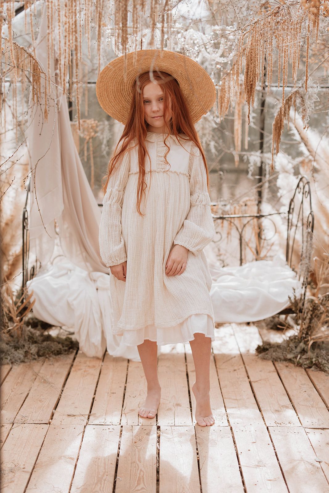 Romantic vintage style photo with straw hat and white cotton dress in crystal-adorned setting.