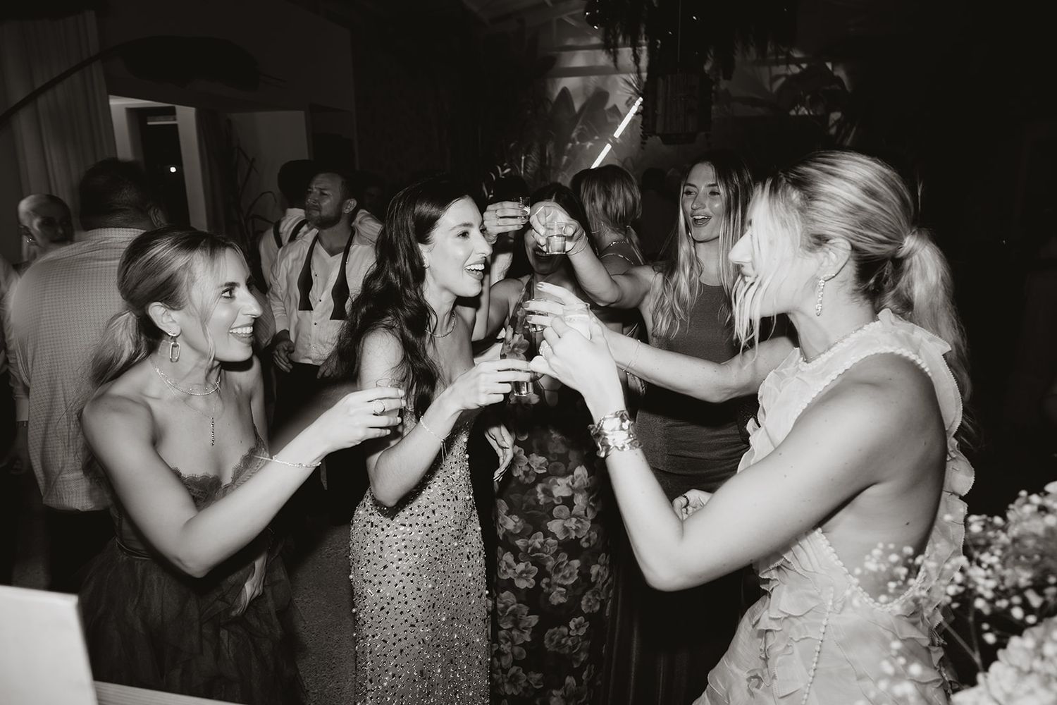 Group of friends toasting and celebrating at a formal party in black and white.