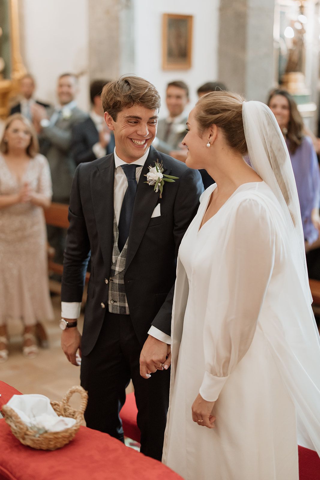 Joyful wedding ceremony moment as couple stands together at altar with guests in background.