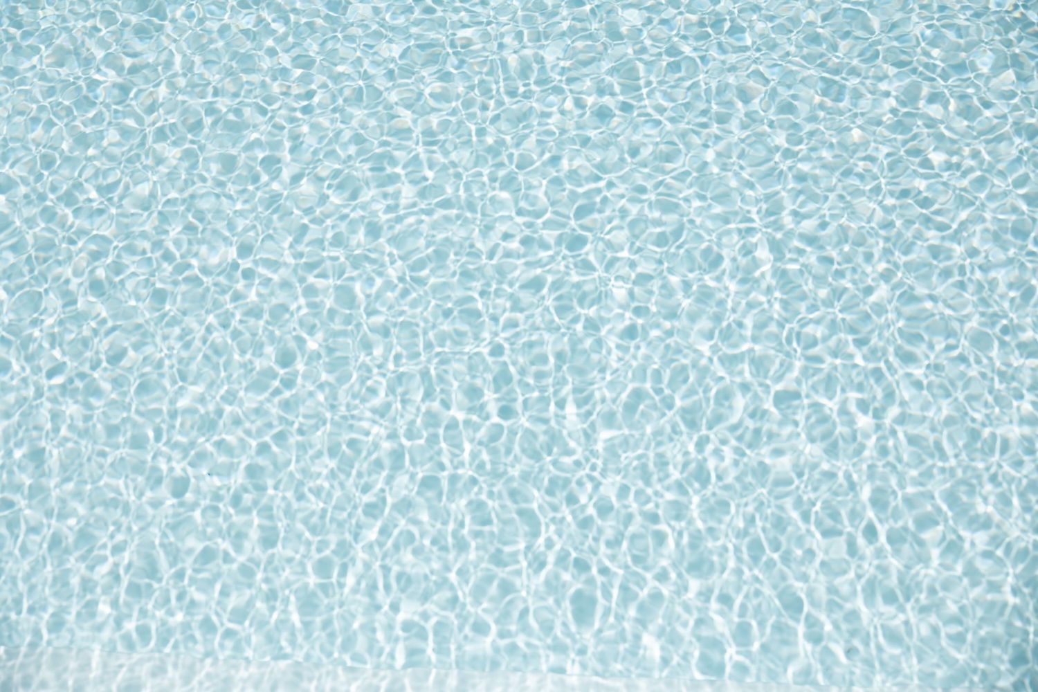 Rippling blue water surface pattern in swimming pool.