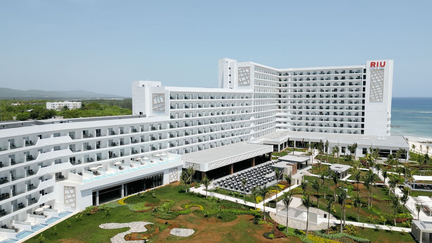 Expansive beachfront resort complex with white architecture and landscaped grounds viewed from above.