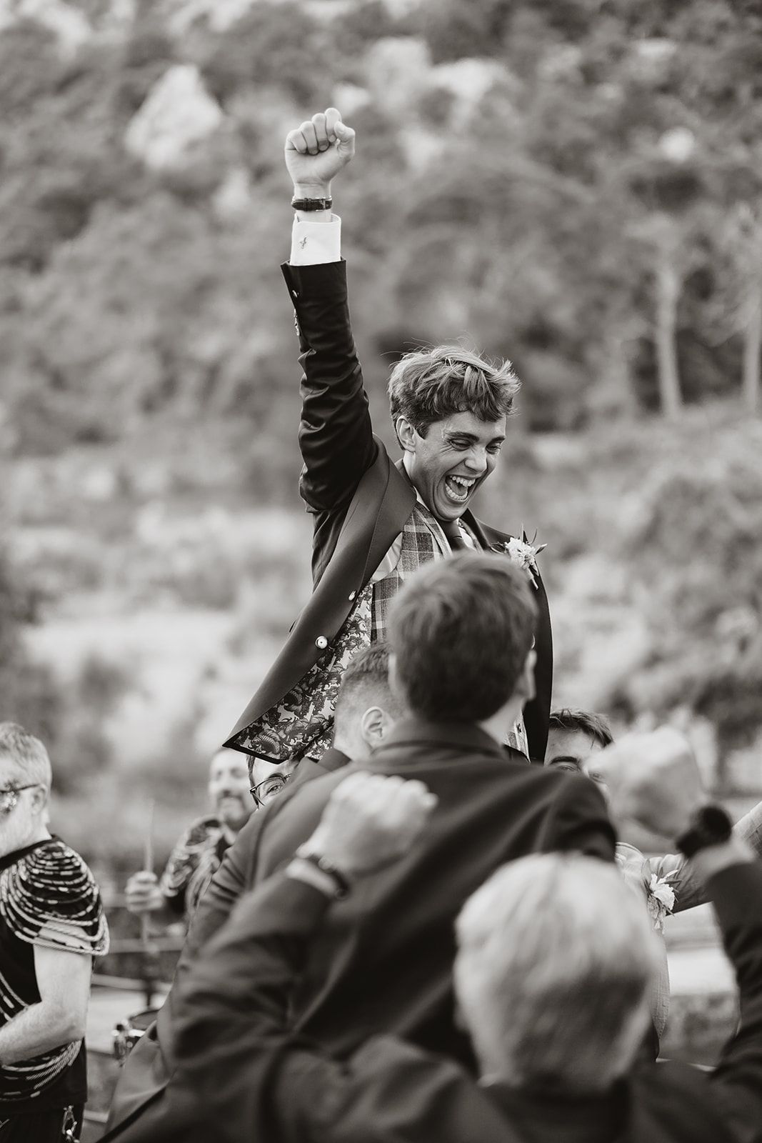 A joyful celebration moment captured in black and white as a guest is lifted above the crowd.