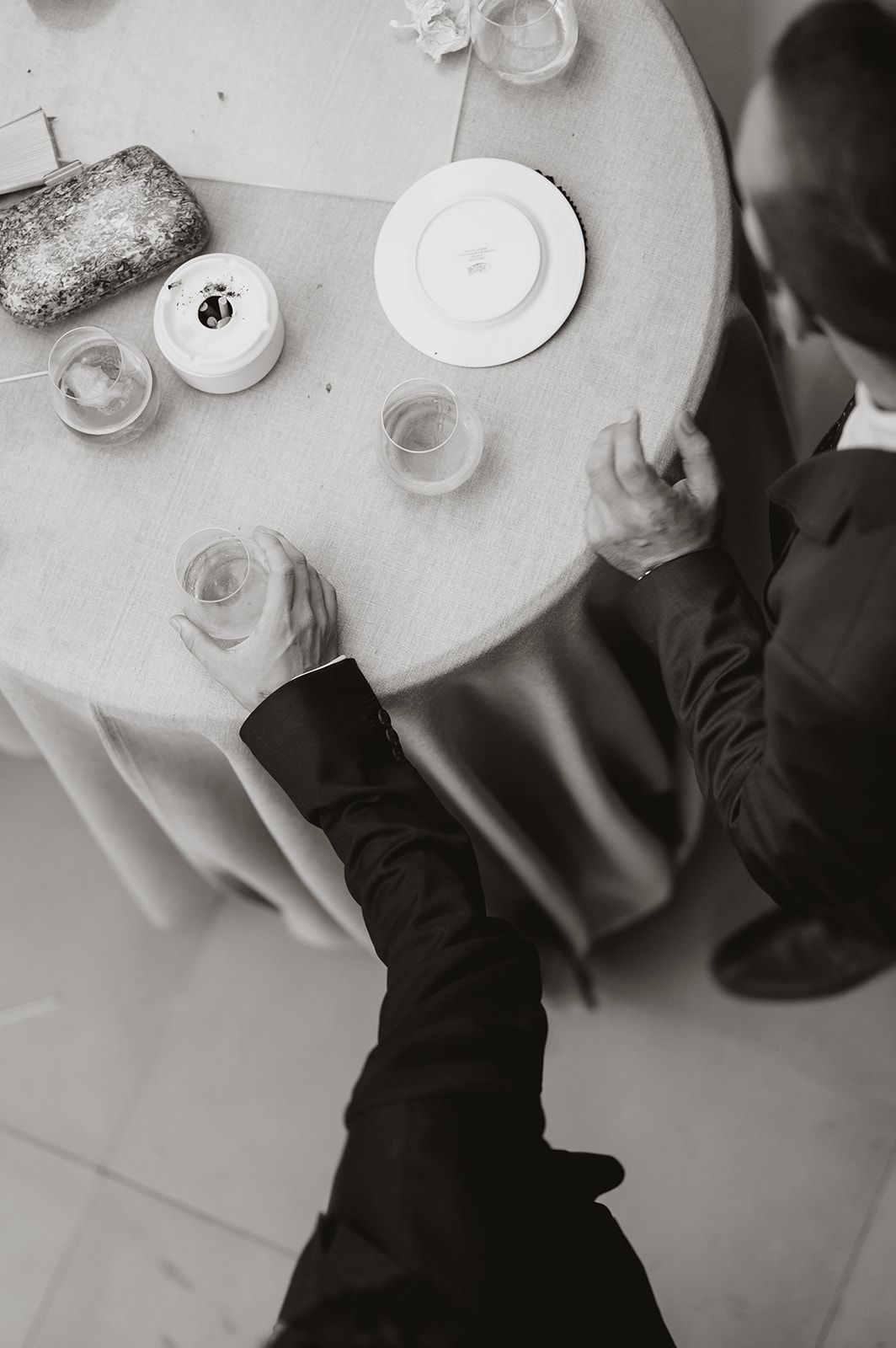 Black and white overhead view of place settings at a formal dining table.