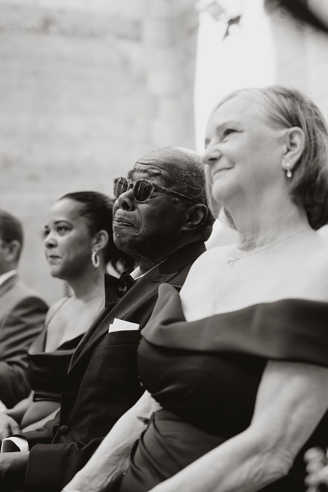 Wedding guests watching ceremony in formal attire at cathedral venue.