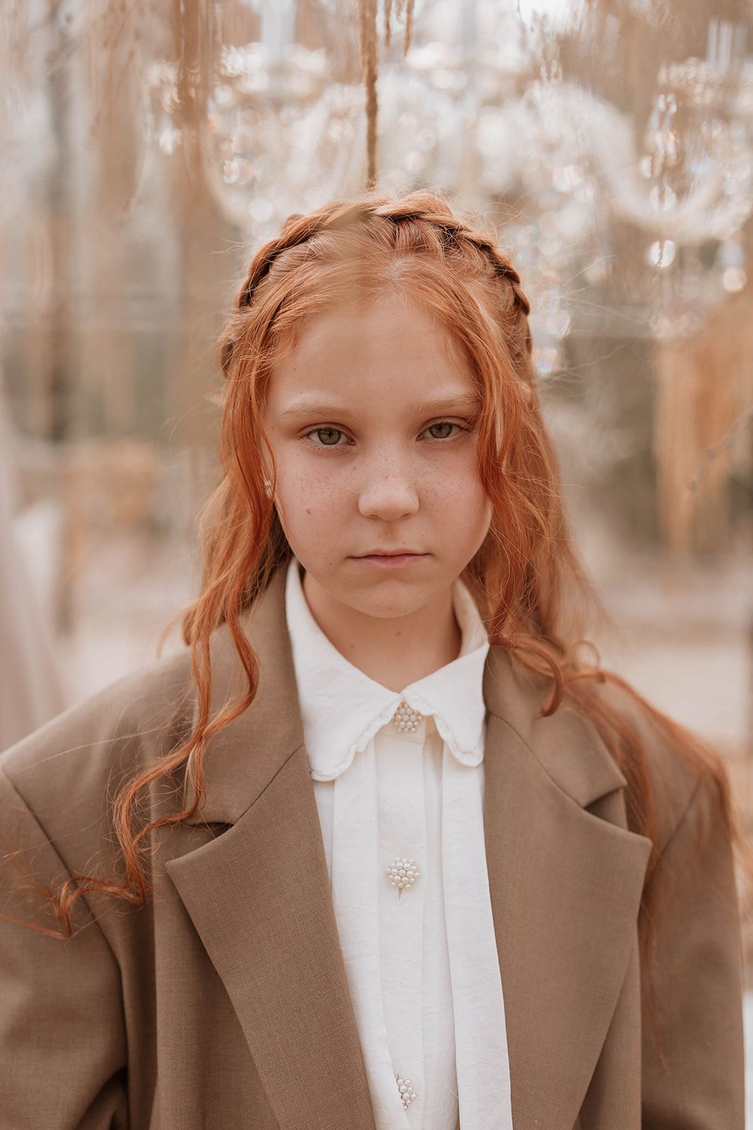 Fashion portrait in sepia tones showcasing braided hairstyle and brown coat with white collar.