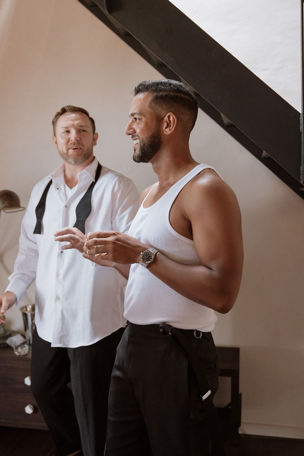 Two people in casual formal wear sharing conversation and drinks.