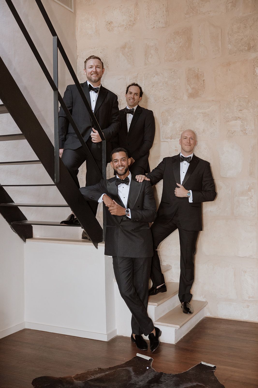 Wedding party in formal attire poses elegantly on modern staircase.
