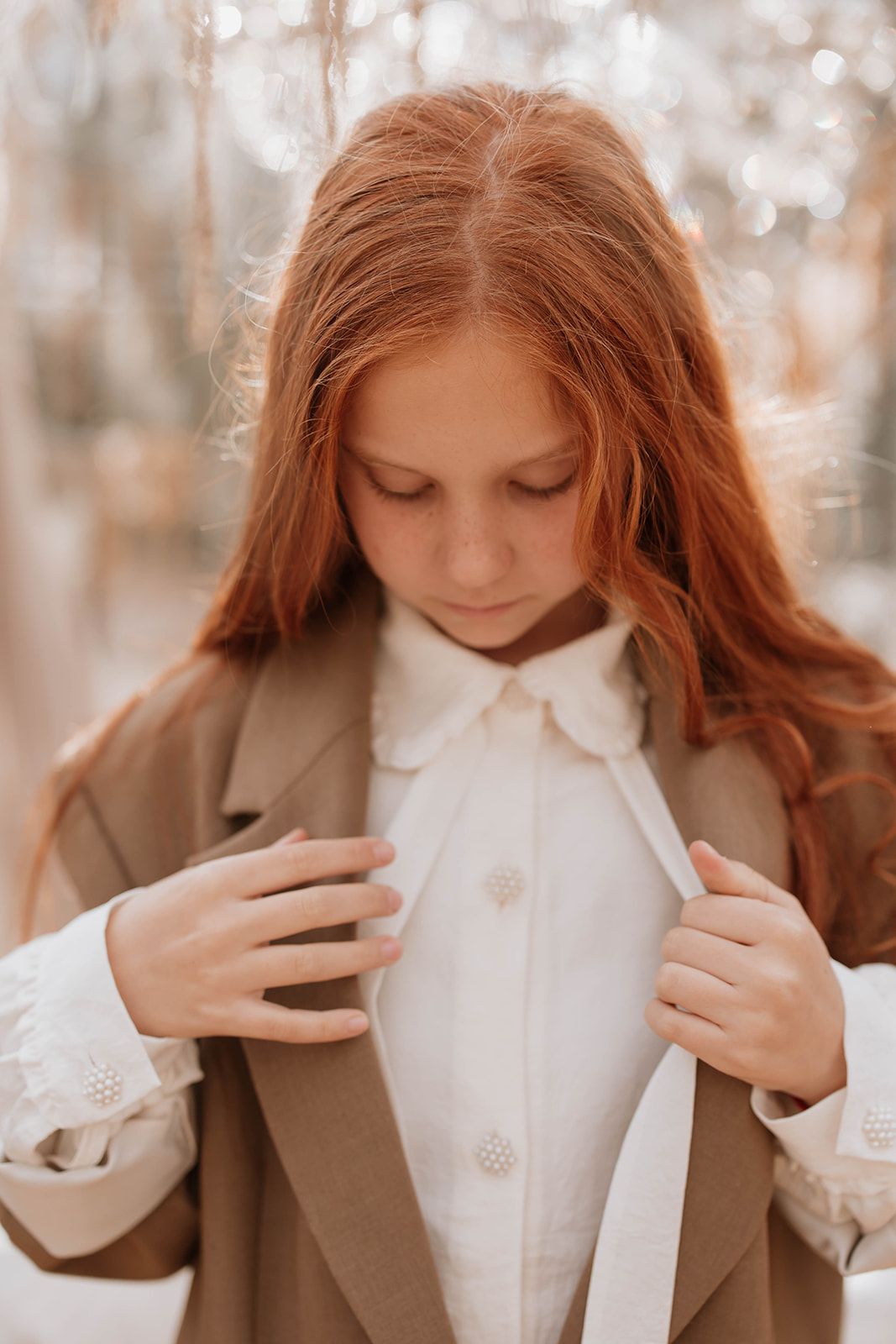 Close-up fashion portrait showcasing a classic white collar shirt and brown oversized coat.