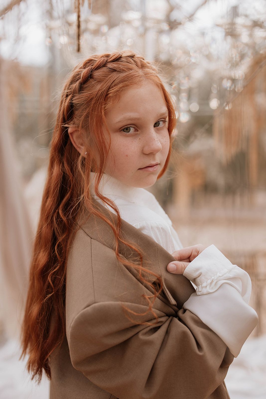Ethereal winter fashion photograph featuring braided hair and classic brown coat.