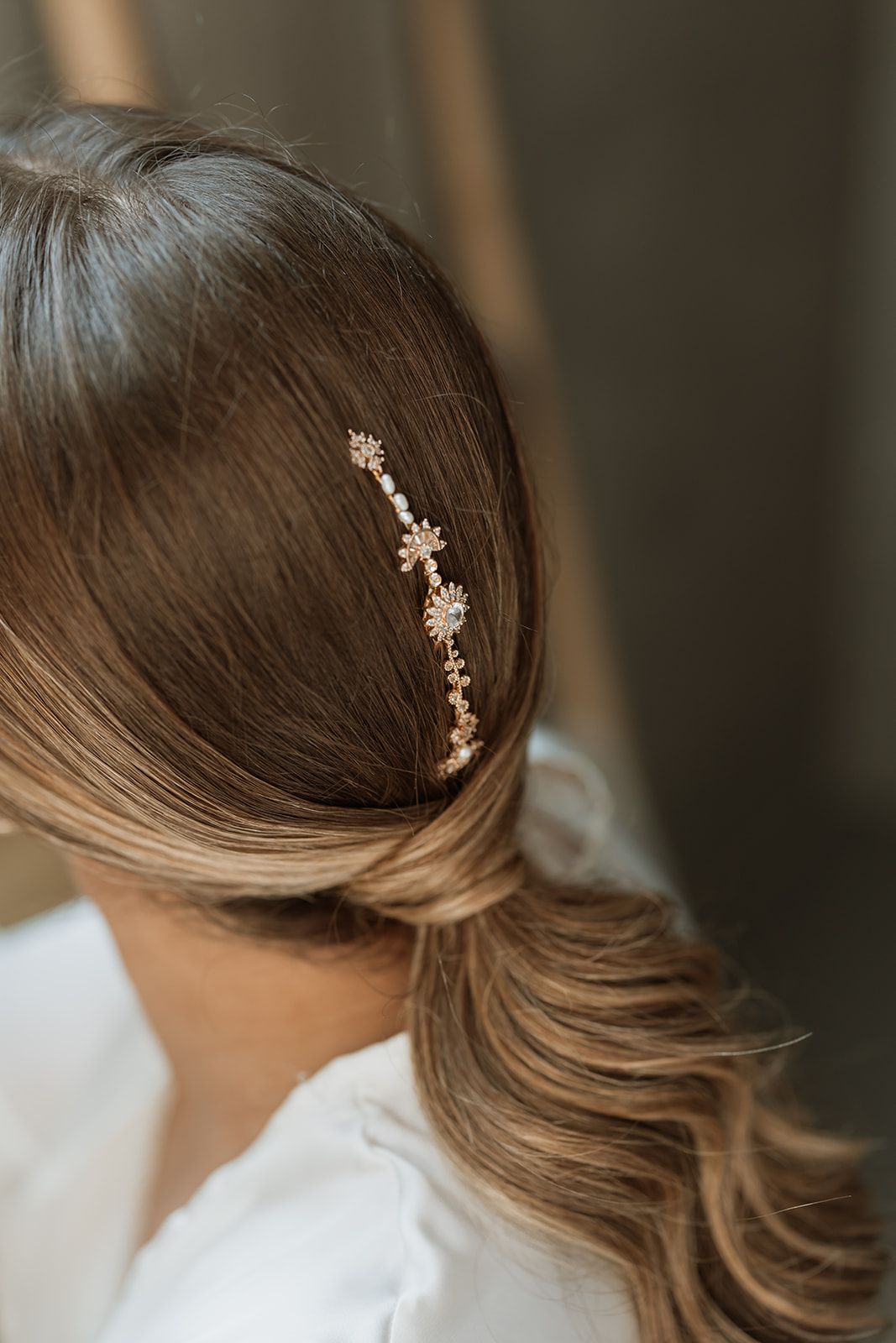 Delicate floral hair accessory adorning wavy brown hair.