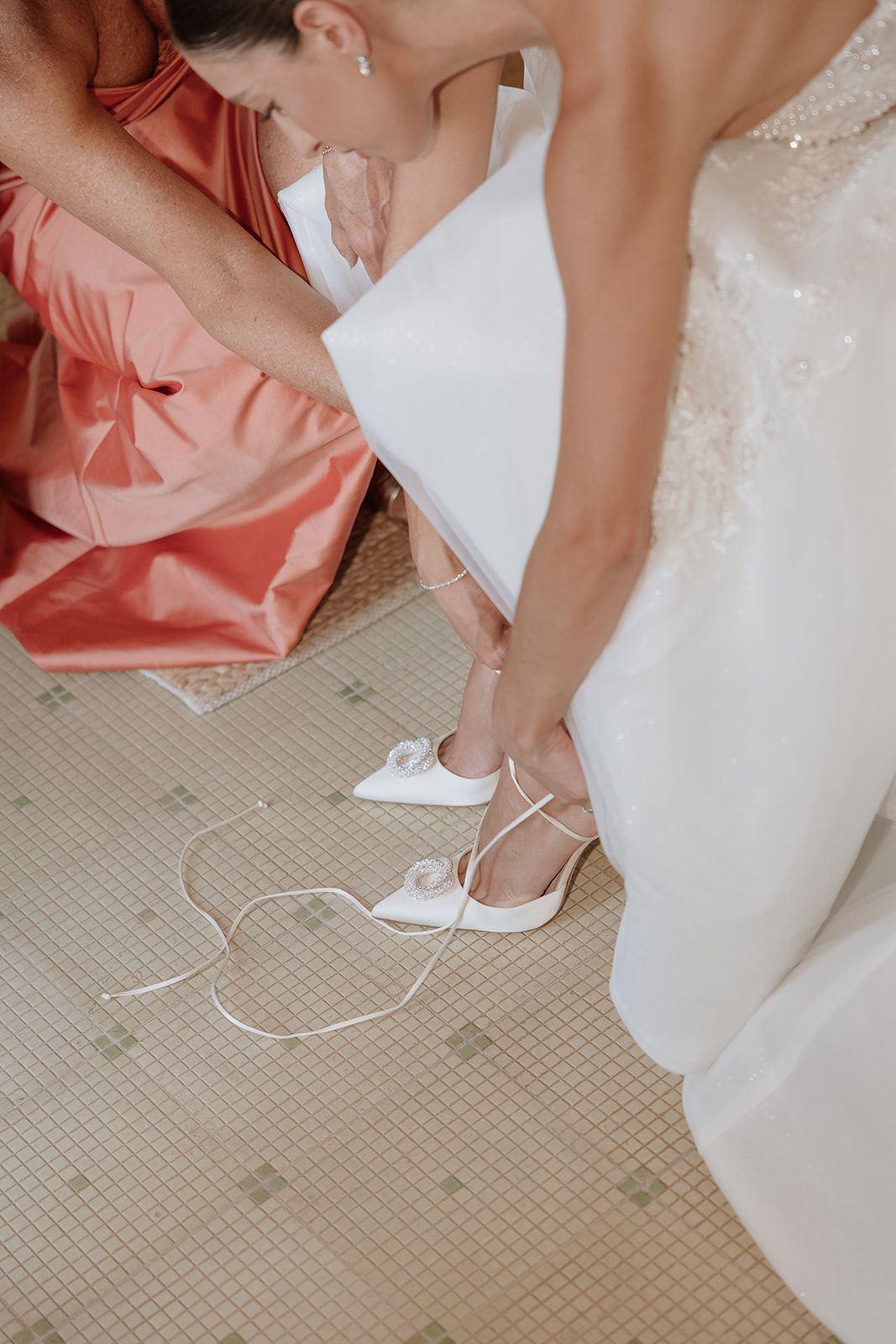 Close-up shots showing bridal shoes and dress details on a tiled floor.