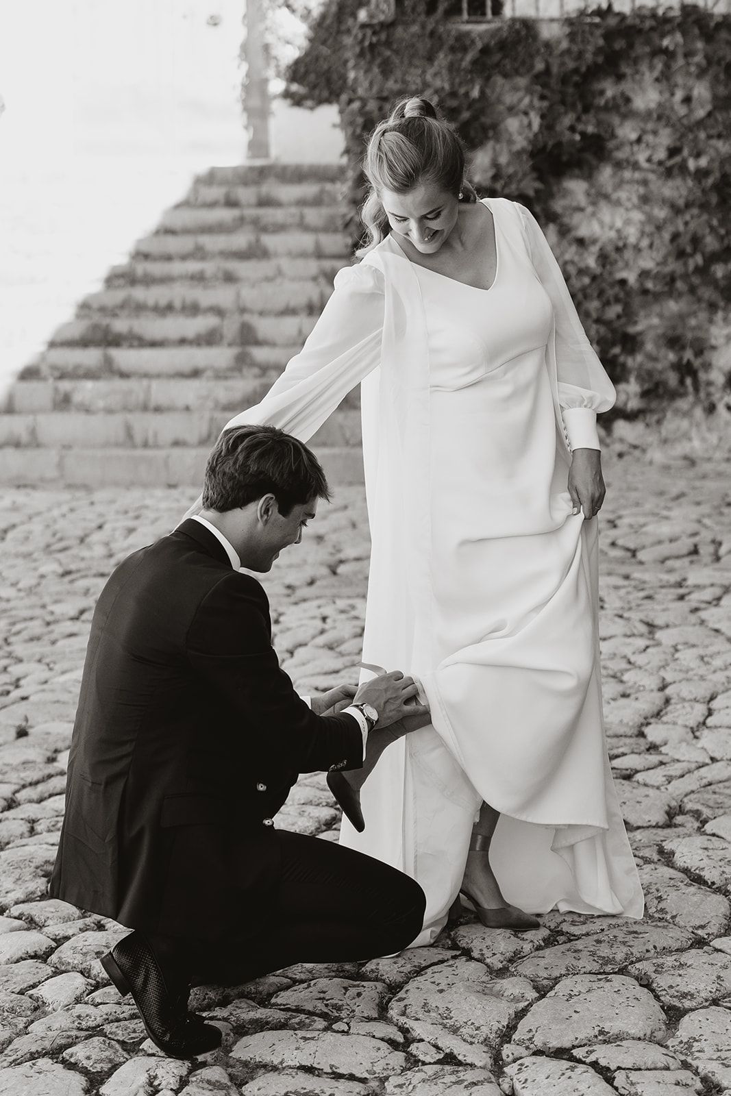 Romantic moment captured on cobblestone path during wedding ceremony.