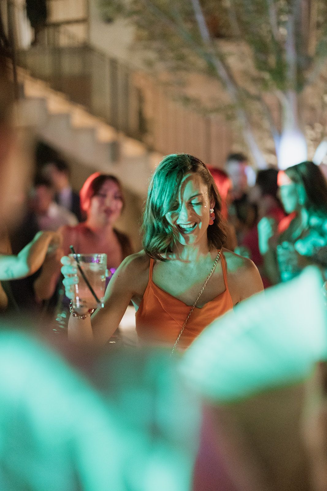 Woman dancing under ethereal green lighting at a festive celebration.