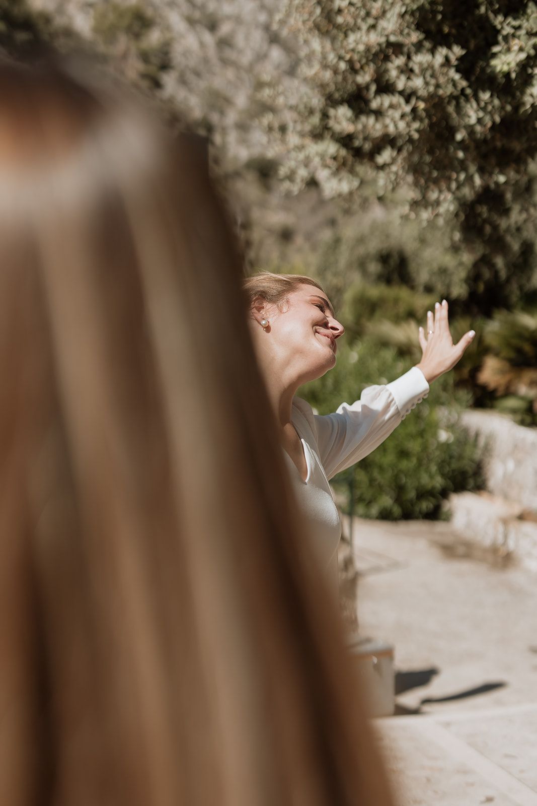 A person in white raises their hand in celebration during an outdoor event.