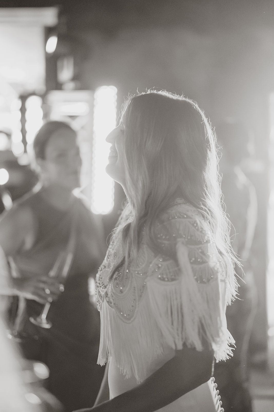 Black and white portrait of person in flowing dress at a party.