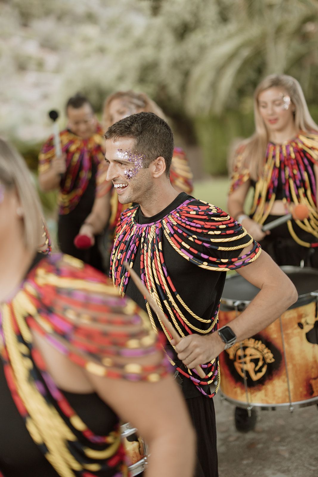 Performer in colorful striped costume dances during an outdoor celebration.