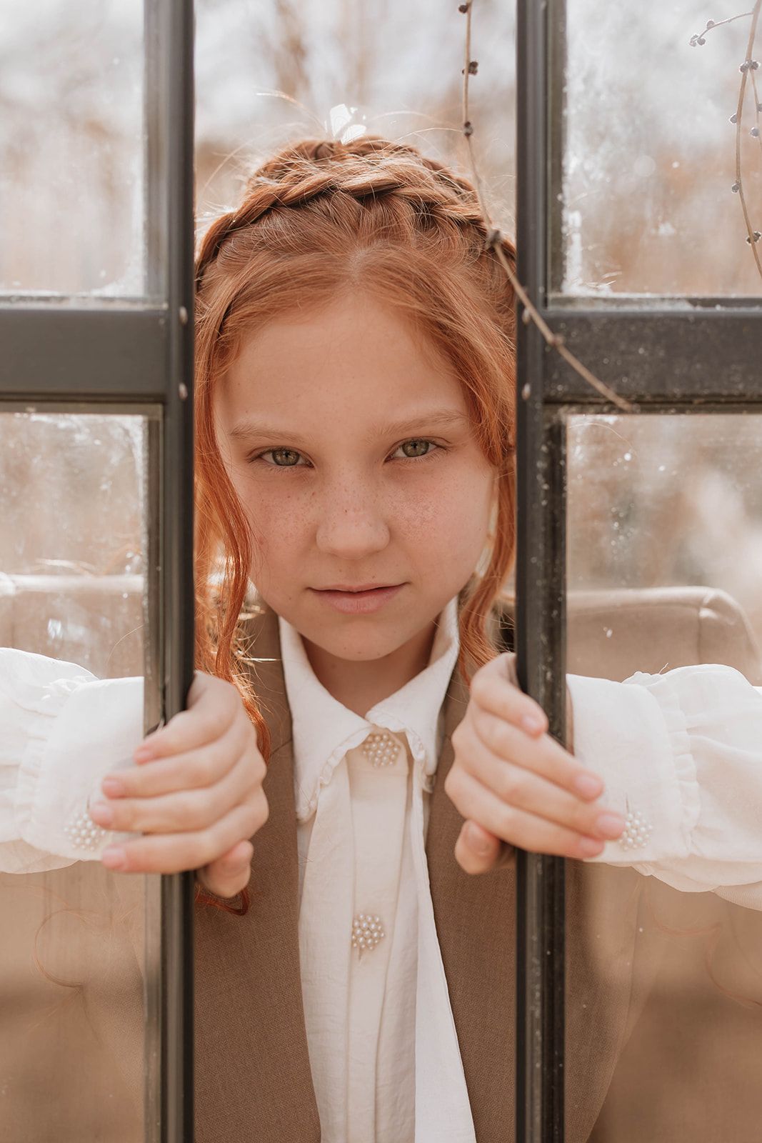 Close-up greenhouse portrait showing braided hair and classic white collar fashion styling.