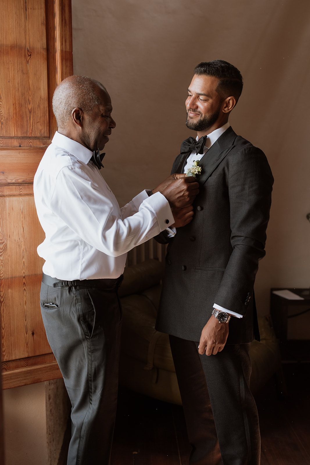 Two people sharing a moment during formal wedding preparations.