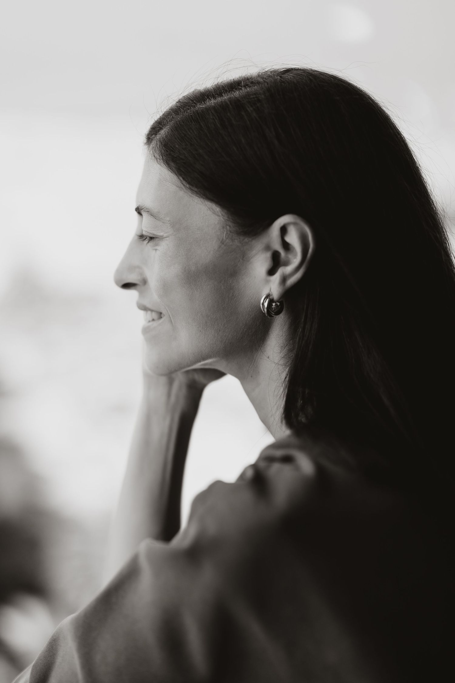 Side profile portrait in black and white with soft lighting.