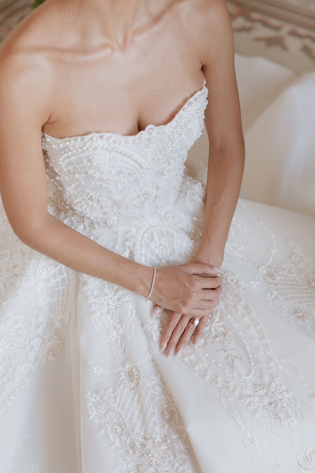 Detailed shots of an ornate white lace wedding dress bodice with beading and pearls.